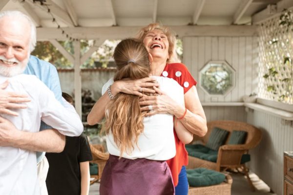 A heartwarming reunion with family members hugging and smiling in a cozy indoor setting.