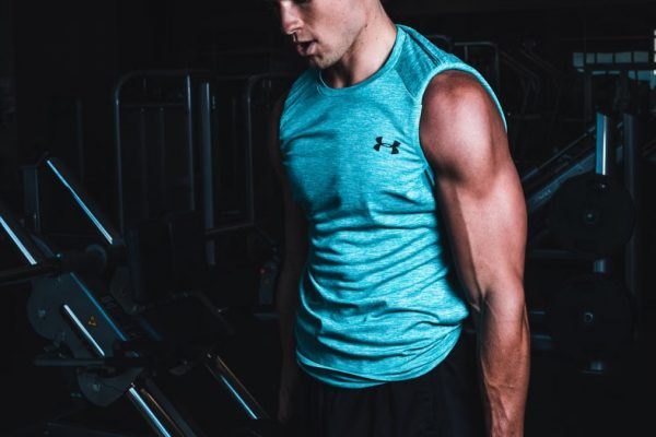 Man exercising indoors, lifting dumbbells for strength training in a Towson gym.