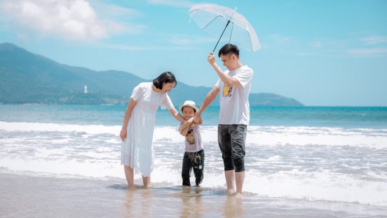 A joyful family enjoying a sunny day at Da Nang Beach, Vietnam, showcasing a heartwarming moment.